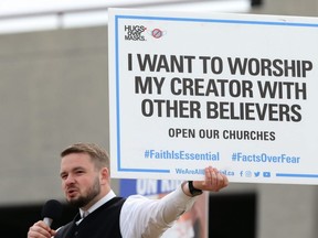 Tobias Tissen, minister at Church of God Restoration near Steinbach, holds a sign as he speaks during an anti-mask rally at The Forks in Winnipeg on Sun., April 25, 2021. KEVIN KING/Winnipeg Sun/Postmedia Network