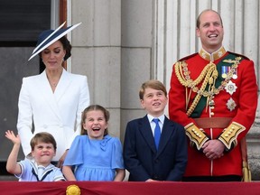 Britain's Catherine, Duchess of Cambridge (left) and Prince William, Duke of Cambridge (right), stand with their children Prince Louis, Princess Charlotte and Prince George to watch a special flypast from Buckingham Palace balcony following the Queen's Birthday Parade, the Trooping the Colour, as part of Queen Elizabeth II's platinum jubilee celebrations, in London, June 2, 2022.
