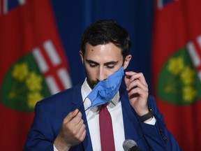 Ontario Education Minister Stephen Lecce takes his mask off before answering questions at Queen's Park in Toronto on Wednesday, June 2, 2021.