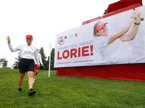 Lorie Kane walks past a 'thank-you' sign bearing her likeness near the 15th green at the Ottawa Hunt and Golf Club on Friday.