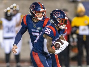 Montreal Alouettes quarterback Trevor Harris hands the ball to running back Walter Fletcher during second half of Canadian Football League game in Montreal Sept. 23, 2022.