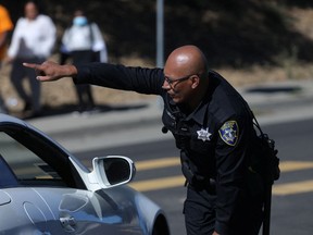 A police officer directs traffic at a road closure after a shooting near a school in Oakland, California September 28, 2022.