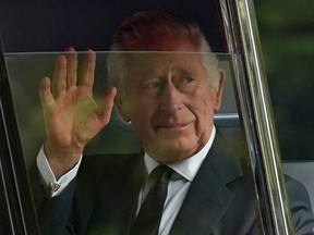 Britain's King Charles III waves to the crowds after leaving Clarence House in central London, Wednesday, Sept. 14, 2022, ahead of the ceremonial procession of the coffin of Queen Elizabeth II, from Buckingham Palace to Westminster Hall.