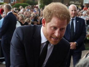 Britain's Prince Harry greets people as he walks outside Windsor Castle, following the passing of Britain's Queen Elizabeth, in Windsor, Britain, Saturday, Sept. 10, 2022.