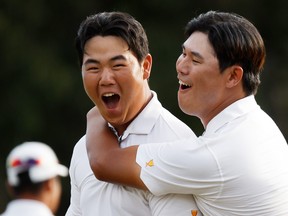 (L-R) Tom Kim of South Korea and teammate Si Woo Kim of South Korea and the International Team celebrate Tom Kim's hole-winning putt to win the match 1 Up against Patrick Cantlay and Xander Schauffele of the United States Team during Saturday afternoon four-ball matches on day three of the 2022 Presidents Cup at Quail Hollow Country Club in Charlotte, North Carolina.