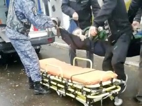 A man is put an a stretcher after a shooting at a military draft office in Ust-Ilimsk, Irkutsk region, Russia September 26, 2022 in this screen grab obtained from social media video.