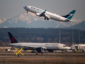 An Air Canada flight departing for Toronto, bottom, taxis to a runway as a Westjet flight bound for Palm Springs takes off at Vancouver International Airport on Friday, March 20, 2020.
