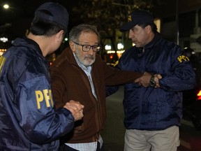 Die Polizei eskortiert Juan Percowicz zur Untersuchungshaft in seinem Haus in Buenos Aires, Argentinien, 30. August 2022.