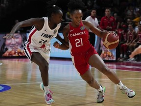 Canada's Nirra Fields, right, runs past France's Mamignan Toure during their game at the women's Basketball World Cup in Sydney, Australia, Friday, Sept. 23, 2022.