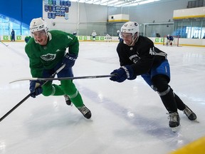 Vancouver Canucks' William Lockwood, left, and Quinn Hughes vie for the puck during training camp in Whistler on Thursday, Sept. 22, 2022.