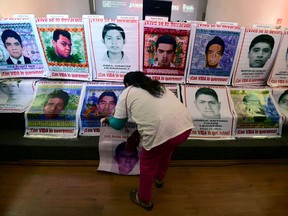 Ein Verwandter eines der 43 vermissten Studenten von Ayotzinapa hängt Plakate mit ihren Bildern vor einer Pressekonferenz von Mitgliedern des argentinischen Teams für forensische Anthropologie (EAAF) in Mexiko-Stadt am 9. Februar 2016 auf.