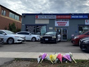 Flowers are laid outside a business in Milton, Ont., Tuesday, Sept. 13, 2022. Police say a man has died after shootings in the Greater Toronto and Hamilton Area Monday that also killed two others.