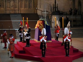 The King's Body Guards of the Honourable Corps of Gentlemen at Arms, the Life Guards, the Blues and Royals and Yeomen of the Guard, stand guard around the coffin of Queen Elizabeth II, inside Westminster Hall, at the Palace of Westminster, in London, Wednesday, Sept. 14, 2022.