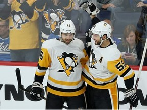 Pittsburgh Penguins centre Zach Aston-Reese (left) celebrates his third-period goal with defenceman Kris Letang during NHL action in Winnipeg on Sun., Oct. 13, 2019.