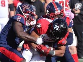 Montreal Alouettes' Micah Awe, left, and Wesley Sutton bring down Ottawa Redblacks's Jackson Bennett during second half in Montreal on Oct. 10, 2022.
