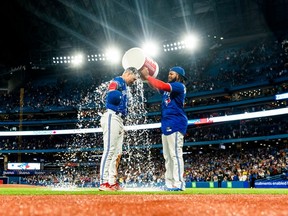 Whit Merrifield of the Blue Jays gets water dumped on him by teammate Vladimir Guerrero Jr. after their team defeated the Boston Red Sox at the Rogers Centre on Oct. 2, 2022 in Toronto.