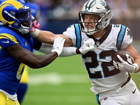 Christian McCaffrey of the Carolina Panthers stiff arms Derion Kendrick of the Los Angeles Rams at SoFi Stadium on October 16, 2022 in Inglewood, California.