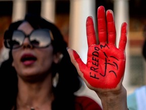 A protestor with her hand stained in red paint reading ''freedom'' takes part in a protest sparked by the death of Mahsa Amini in the custody of Iran's notorious morality police, in Athens, Saturday, Oct. 1, 2022.