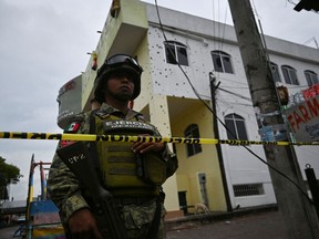 A member of security forces stands guard outside San Miguel Totolapan town hall October 6, 2022.