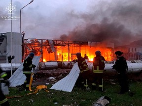 Firefighters work at the site of a car retailer office building, destroyed during a Russian missile attack in Zaporizhzhia, Ukraine October 11, 2022.