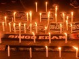 Football supporters hold candlelight vigil for victims of a stampede, in Bekasi on October 3, 2022. - Anger against police mounted in Indonesia on October 3 after at least 125 people were killed in one of the deadliest disasters in the history of football, when officers fired tear gas in a packed stadium, triggering a stampede.