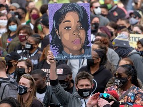 A protestor brandishes a portrait of Breonna Taylor during a rally in remembrance on the one year anniversary of her death in Louisville, Kentucky.
