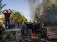 In this photo taken by an individual not employed by the Associated Press and obtained by the AP outside Iran, Iranians protests the death of 22-year-old Mahsa Amini after she was detained by the morality police last month, in Tehran, Oct. 27, 2022. Foreign Affairs Minister Mélanie Joly says Canada is adding Iran's national police force and an Iranian international university to its sanctions list.