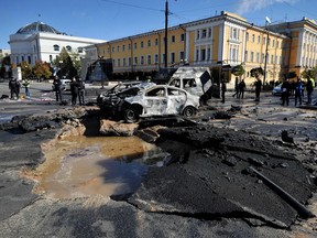 Polizeiexperten untersuchen zerstörte Autos im Zentrum von Kiew nach mehreren russischen Streiks am 10. Oktober 2022.
