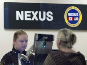 A Canada Border Services Agency officer speaks with a traveller at the Nexus office at the airport in Ottawa, May 8, 2012.