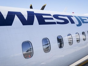 A WestJet plane waits at a gate at Calgary International Airport in Calgary, Aug. 31, 2022.