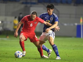 Samuel Piette of Canada fights for the ball with Tanaka Ao of Japan during the international friendly between Japan and Canada at Al-Maktoum Stadium on November 17, 2022 in Dubai, United Arab Emirates.