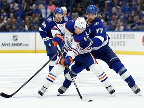 Ryan Nugent-Hopkins #93 of the Edmonton Oilers and Victor Hedman #77 of the Tampa Bay Lightning fight for the puck during a game at Amalie Arena on November 08, 2022 in Tampa, Florida.