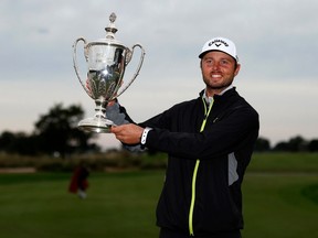 Surrey's Adam Svensson poses with the trophy after putting in to win on the 18th green at Sea Island Resort Seaside Course on Nov. 20, 2022 in St Simons Island, Georgia.