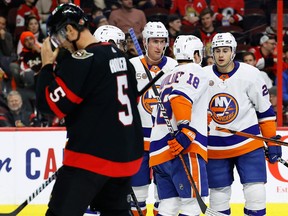 Ottawa Senators defenceman Nick Holden (5) skates by as New York Islanders players celebrate a goal.