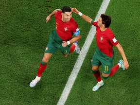 Cristiano Ronaldo (left) of Portugal celebrates with Joao Felix after scoring their team's first goal via a penalty against Ghana.