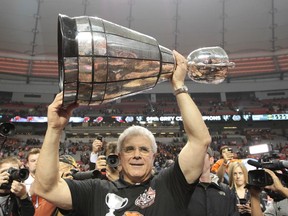 BC Lions' Wally Buono, general manager and ead coach, hoists the Grey Cup after winning the CFL's 99th Grey Cup at B.C. Place in Vancouver in November 2011.