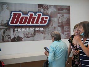 Three older women next to mural that reads 'Bohls Middle School.'