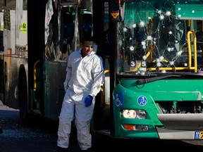 Israeli forensic experts collect evidence at the scene of an explosion at a bus stop in Jerusalem on November 23, 2022.