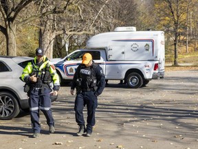 A London police officer and a member of Search and Rescue London search the parking lot at the Grosvenor Street entrance to Gibbons Park on Monday, Nov. 7, 2022. A man was found unresponsive on Sunday and later died in what police are calling a homicide. (Mike Hensen/The London Free Press)