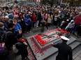 People lay poppies on the Tomb of the Unknown Soldier following the Remembrance Day ceremony at the National War Memorial in Ottawa, Friday, Nov. 11, 2022.