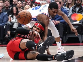 Toronto Raptors' Gary Trent Jr., left, tries to pass as he falls under pressure from Philadelphia 76ers' De'Anthony Melton during first half NBA basketball action in Toronto on Friday, October 28, 2022. Trent Jr. has been ruled out for Toronto's game at Detroit with a sore right hip.