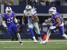 Dallas Cowboys wide receiver Amari Cooper runs the ball after a catch against Buffalo Bills cornerback Tre'Davious White and outside linebacker Matt Milano in the second quarter at AT&T Stadium.