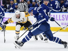 Pittsburgh Penguins forward Sidney Crosby pursues a loose puck with Toronto Maple Leafs forward Mitch Marner in the third period at Scotiabank Arena.