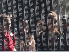 Visitors are reflected by the black marble stone with the names of the Holocaust victims at the Holocaust Memorial Center in Budapest on April 16, 2019.