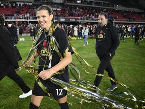 Portland Thorns FC forward Christine Sinclair (12) walks on the field with streamers after the NWSL championship soccer match against the Kansas City Current, Saturday, Oct. 29, 2022, in Washington. Sinclair, who led Portland to the NWSL championship on the weekend, is returning to the Thorns next season.