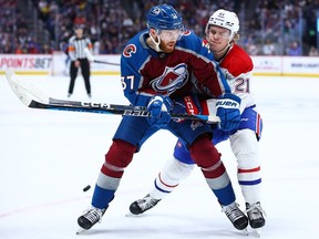 Montreal Canadiens defenceman Kaiden Guhle wages puck battle with J.T. Compher of the Colorado Avalanche during second period at Ball Arena in Denver on Dec. 21, 2022.
