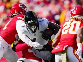 Travis Etienne Jr. of the Jacksonville Jaguars is tackled by Mike Danna of the Kansas City Chiefs during the first half of the game at Arrowhead Stadium on November 13, 2022 in Kansas City, Missouri.