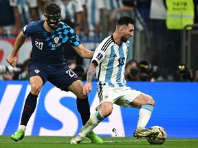 Croatia's defender Josko Gvardiol challenges Argentina forward Lionel Messi.