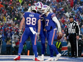 Dawson Knox #88, Spencer Brown #79 and Josh Allen #17 of the Buffalo Bills celebrates a touchdown from Allen in the fourth quarter of a game against the New York Jets at Highmark Stadium on December 11, 2022 in Orchard Park, New York. (Photo by Joshua Bessex/Getty Images)