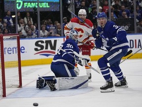 Toronto Maple Leafs goaltender Matt Murray, defenceman Justin Holl and Calgary Flames forward Nazem Kadri watch a rebound go wide of the net Saturday night.  USA TODAY Sports
